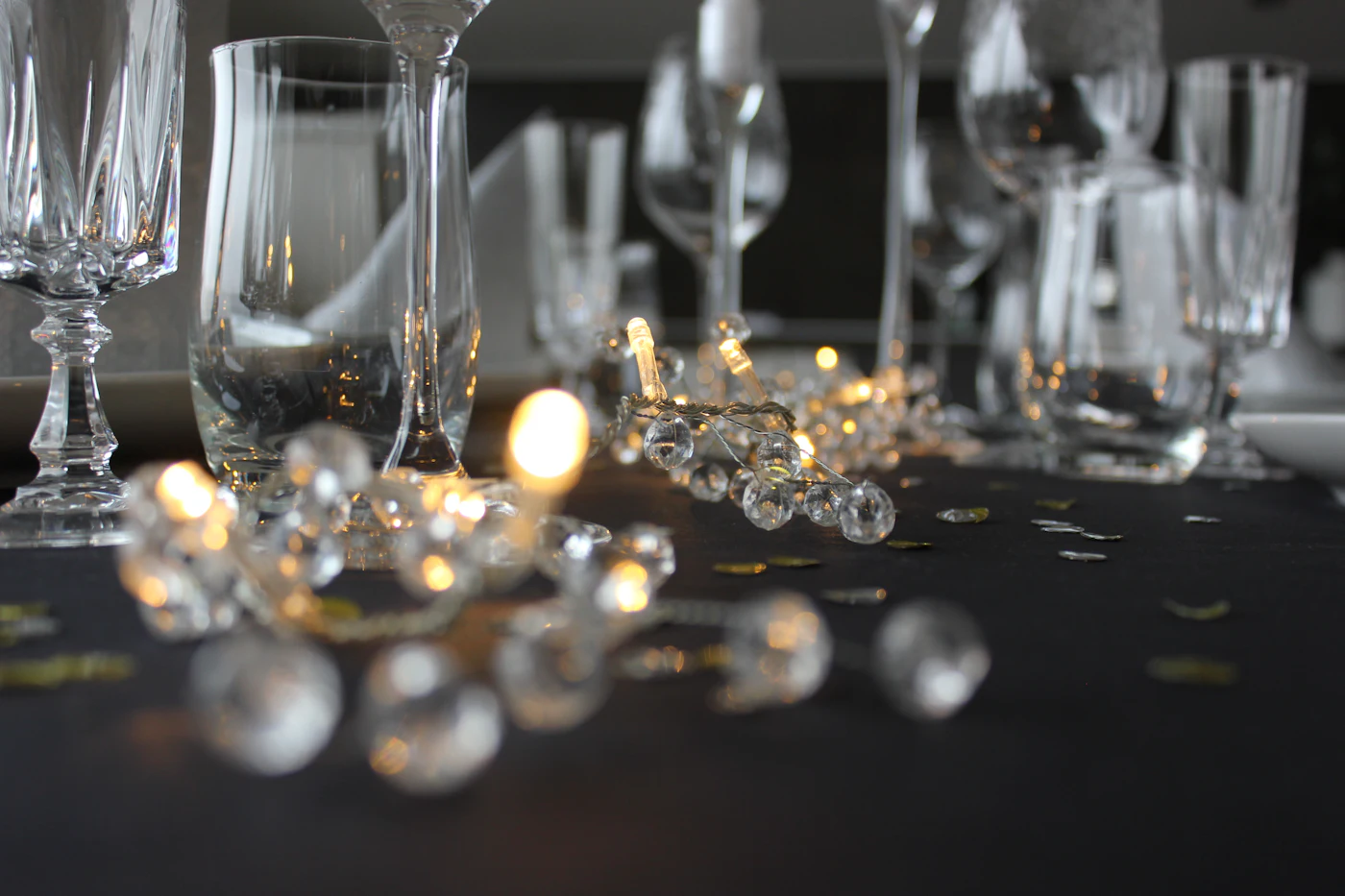 Cut crystal and thin-rimmed wine glasses on a dark cloth, lit low from one side.
